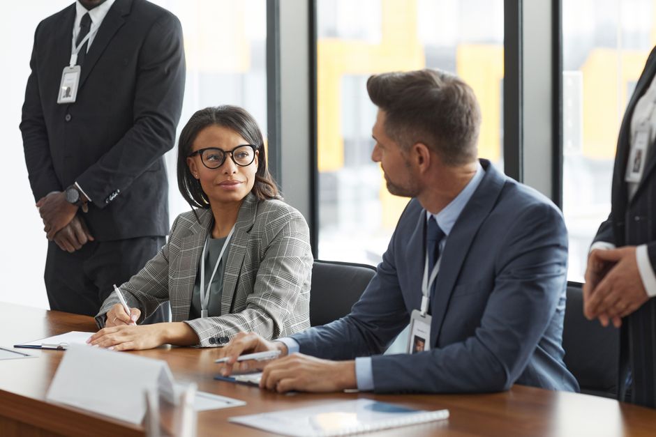 Diverse business professionals discussing strategy during a modern board meeting